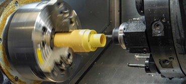 Uma barra de material consistindo de polímeros de alto desempenho iglidur® é torneada para obter a forma certa.