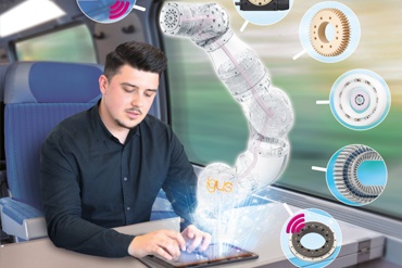 Homem trabalha com tablet no trem e comanda um braço de robô